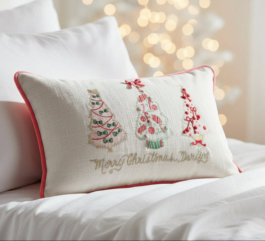 Cream lumbar pillow with red trim and embroidered Christmas tree, deer, and 'Merry Christmas Darling'