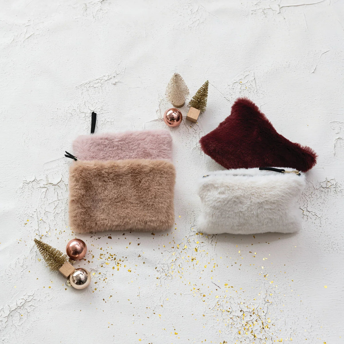 Faux fur zip pouches in pale pink, tan, burgundy, and white