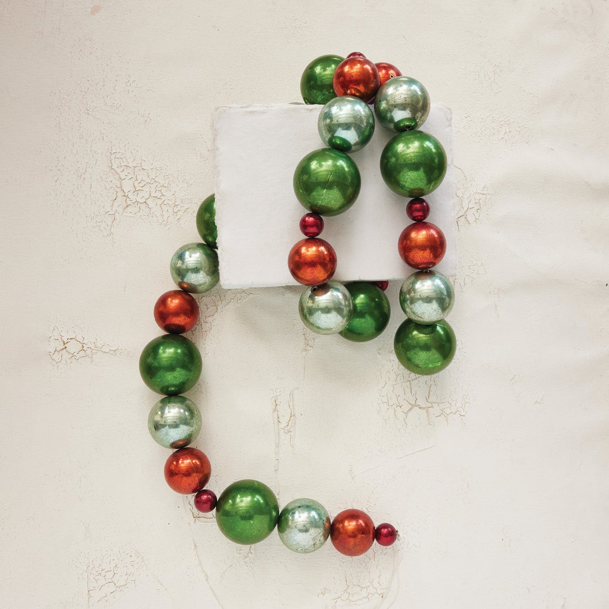 Green and red plastic ball garland with metallic balls, circular wreath shape