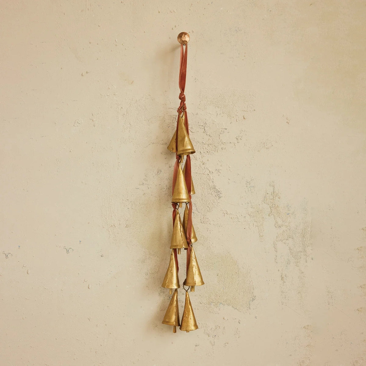 Hanging brass bell ornament with five tiered metal bells on a looped cord