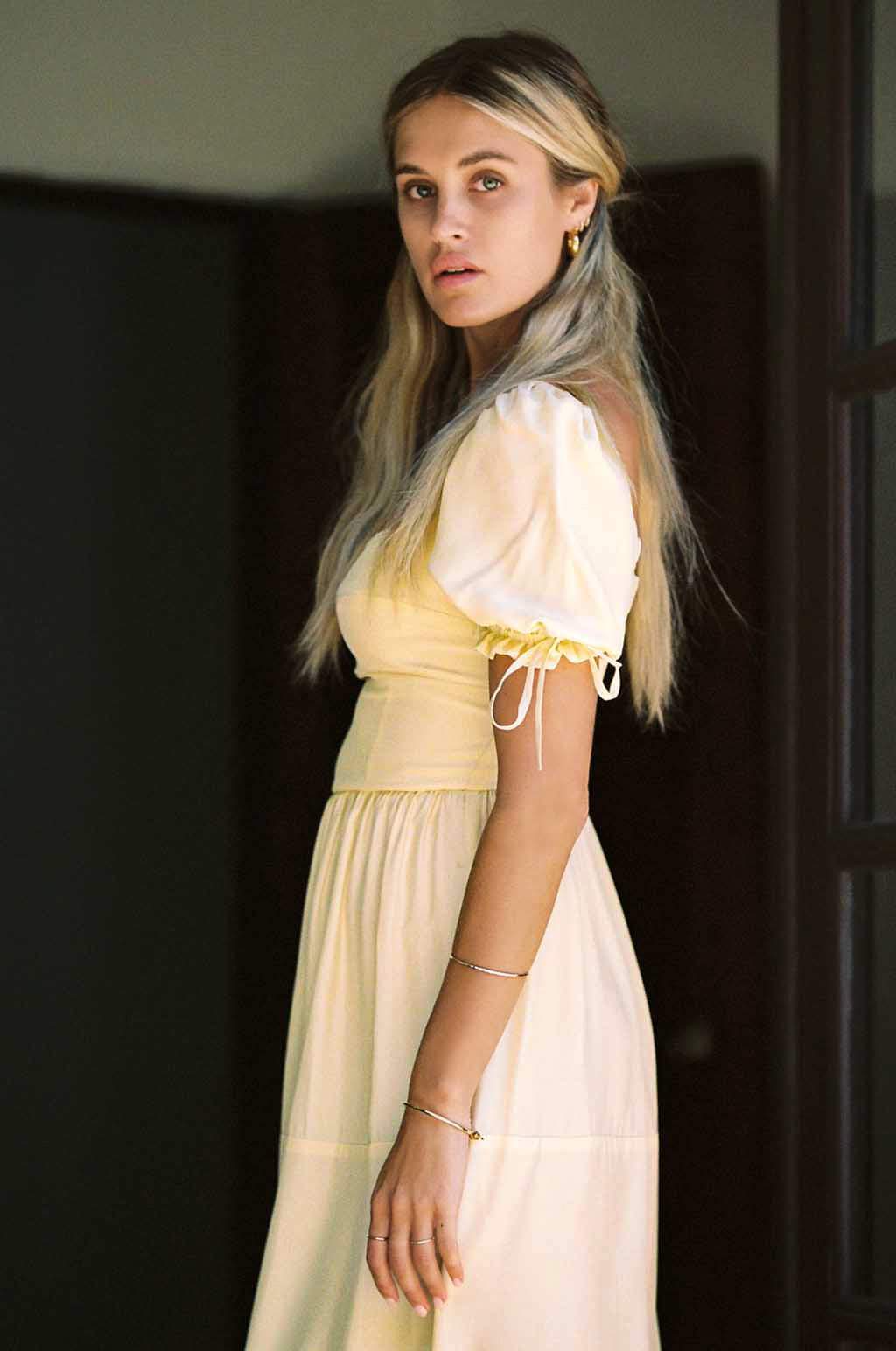 Soft yellow silk midi dress with puff sleeves, lace trim, and tiered skirt