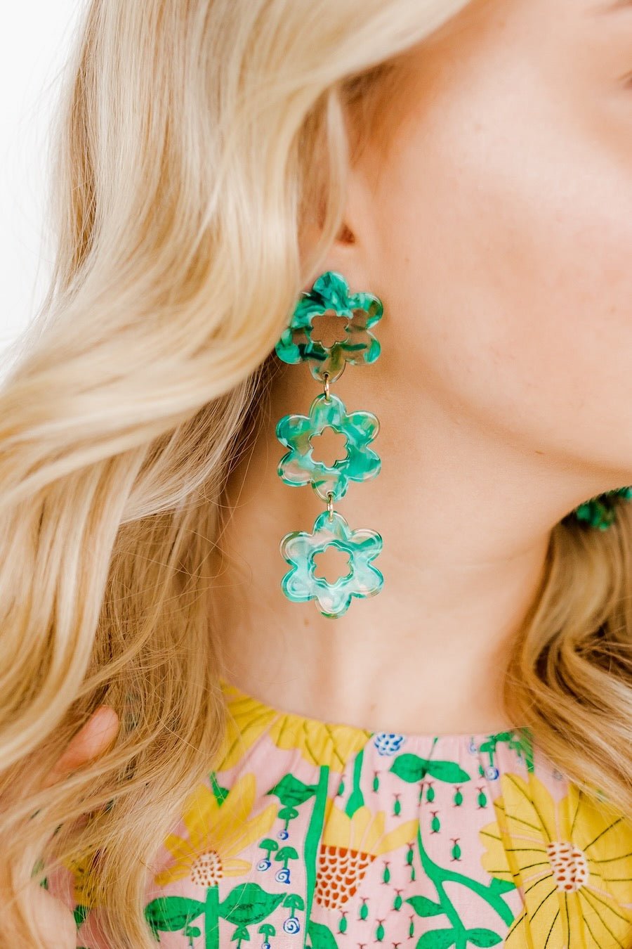 Green clover dangle earrings with white centers, three stacked blossoms on ear