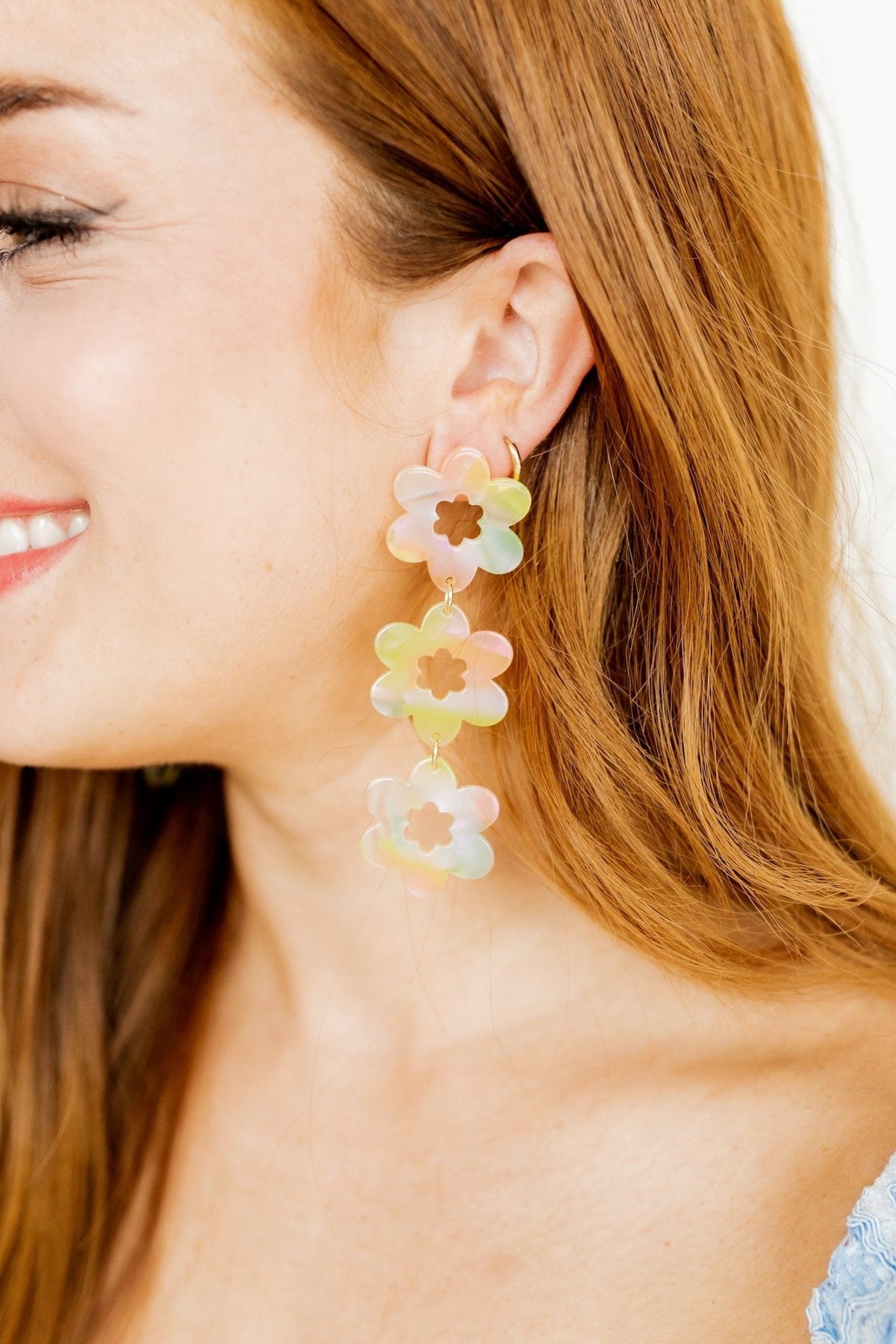 Close-up of pastel floral drop earrings with mint and peach flower charms